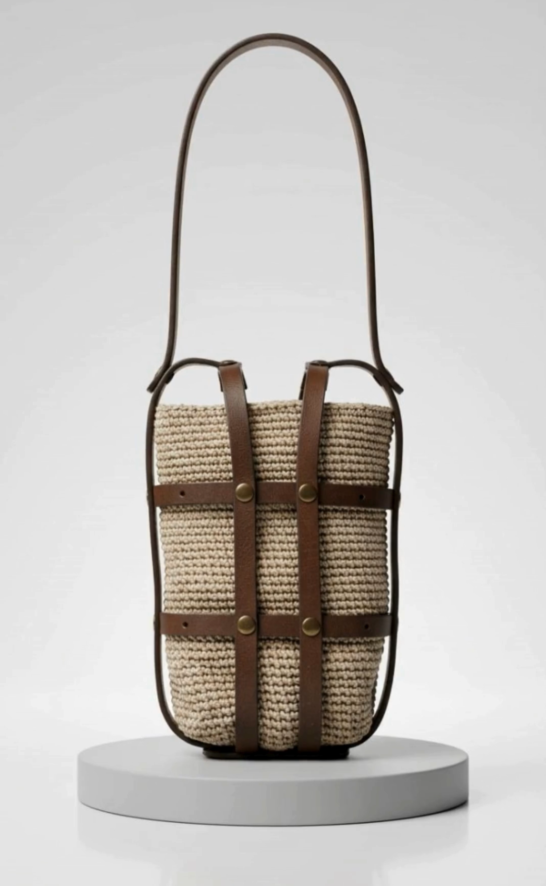 Beige crochet leather phone bag with dark brown leather details displayed in a minimal studio setting
