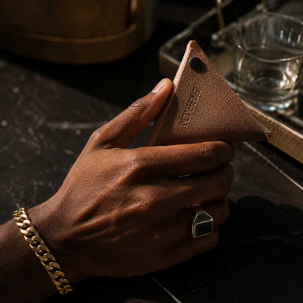 Close-up of a beige leather coin pouch held in hand with premium leather texture visible