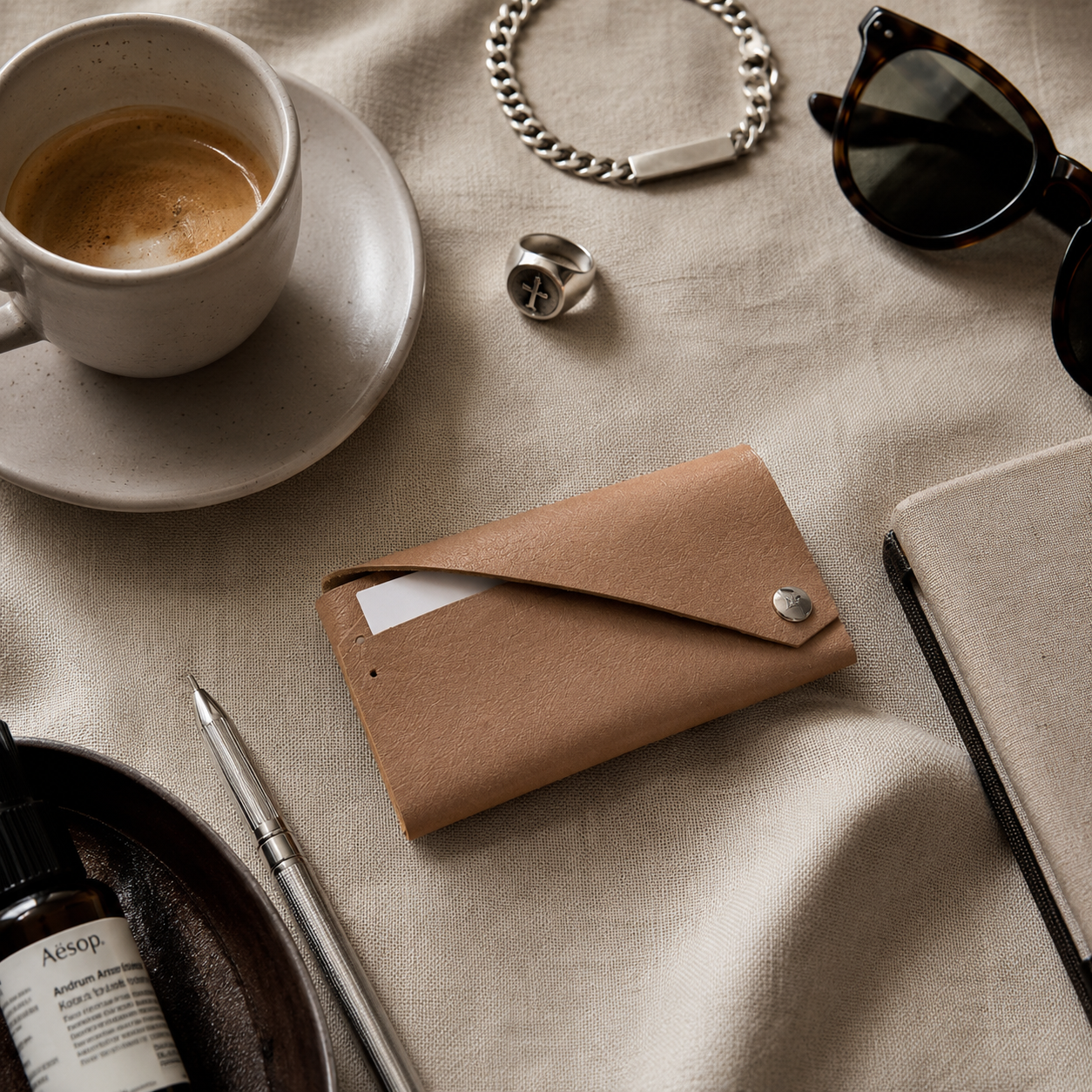 Beige genuine leather envelope card holder styled with coffee, sunglasses and minimalist accessories