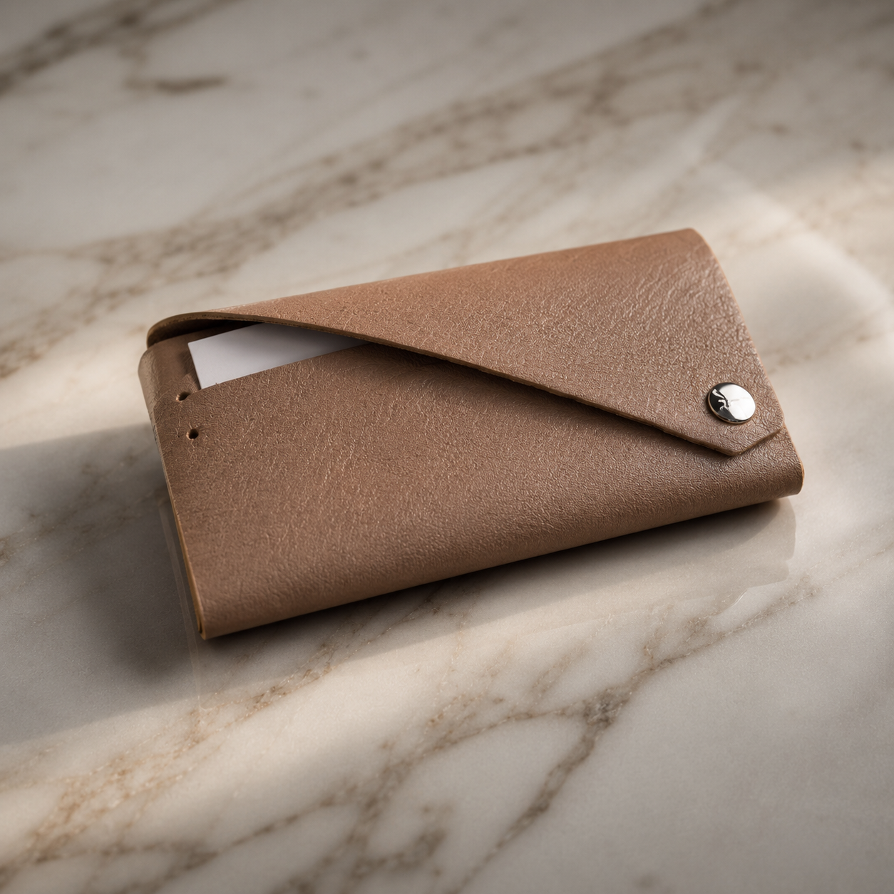 Beige genuine leather envelope card holder displayed on a luxury marble surface