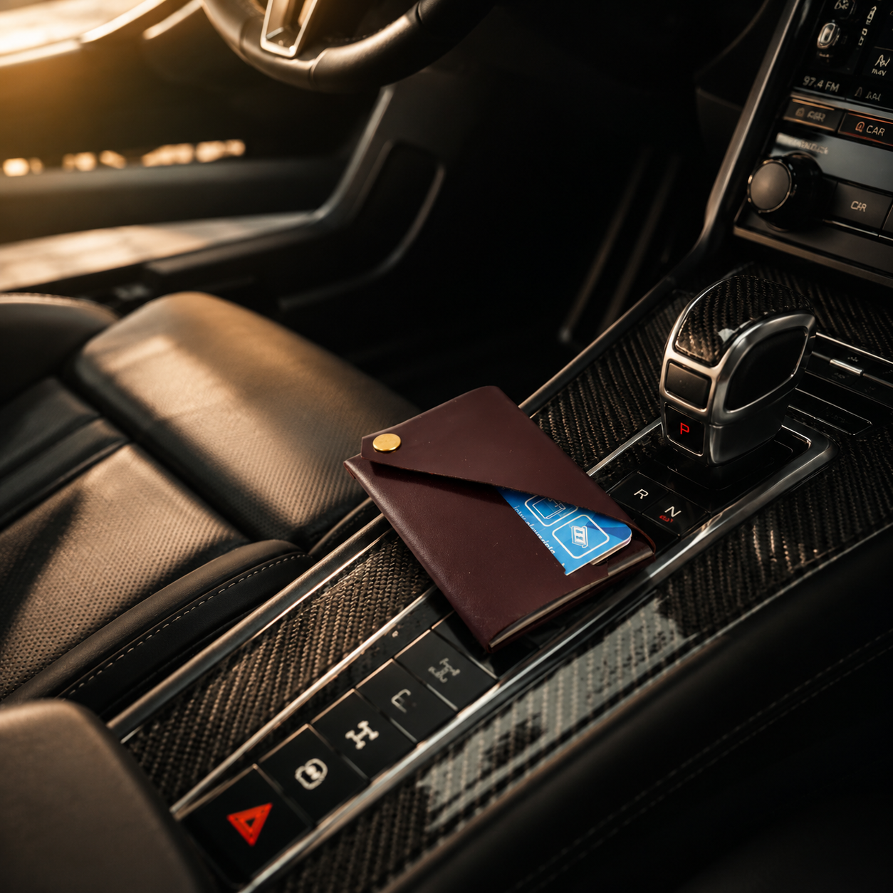 Burgundy patent leather card holder placed on the centre console of a luxury car.