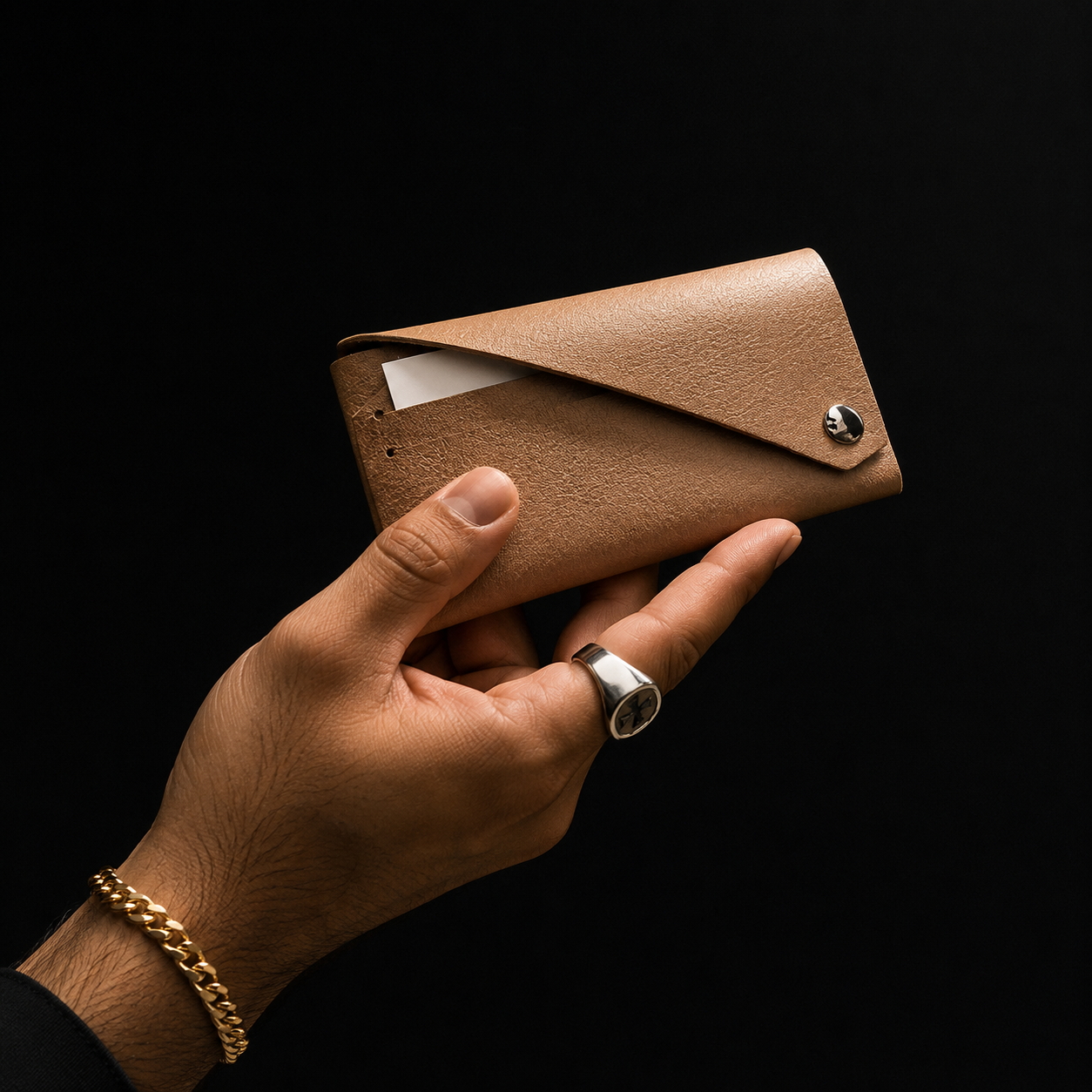 Handmade beige genuine leather envelope card holder held against a dark studio background