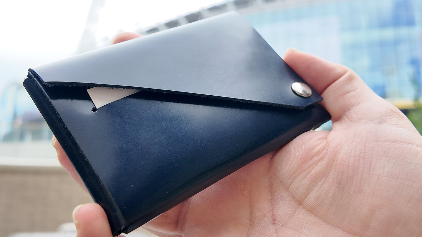 Close-up of a navy patent leather wallet highlighting its glossy leather finish