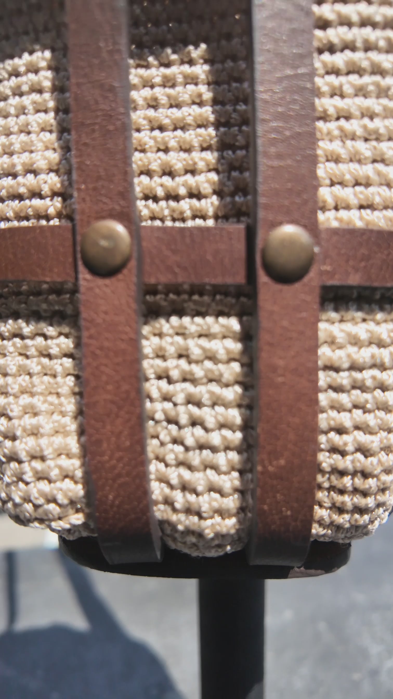 Close-up video of a cream crochet and brown leather crossbody bag showcasing the woven texture, leather straps and brass rivet details.