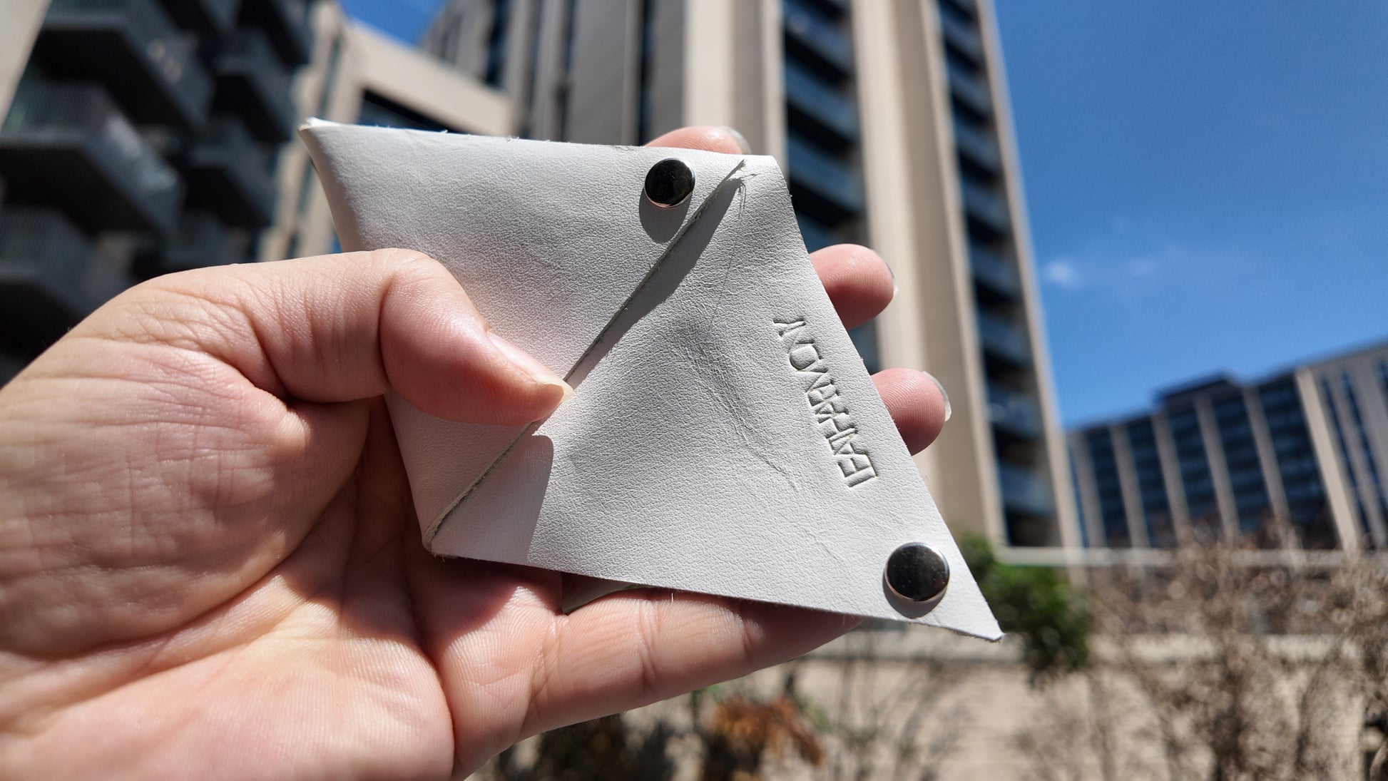 Open white genuine leather coin pouch revealing its minimalist interior construction and craftsmanship.